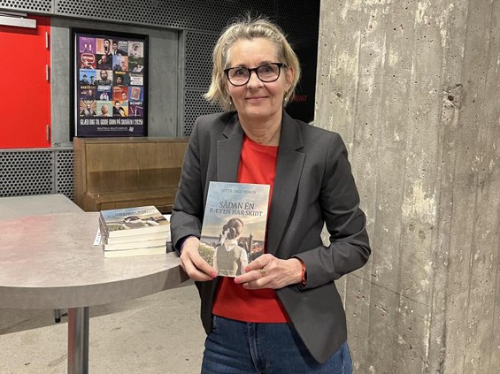 Billede afforfatter Jette Dige Rokos. Står smilende med sin bog i hånden